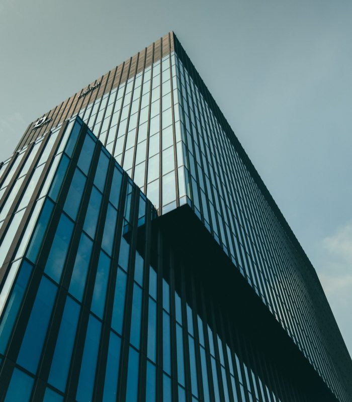 A low angle shot of a building in a glass facade under the beautiful cloudy sky